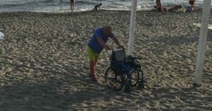 Anziano con disabilità costretto a trascinarsi sulla spiaggia libera di Ostia