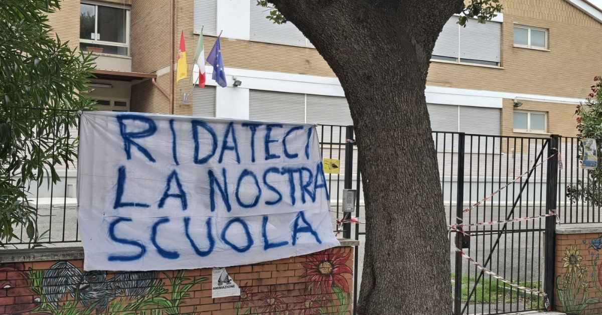 Striscione sul cancello della scuola "Raffaele La Crociera" a Casal Bernocchi