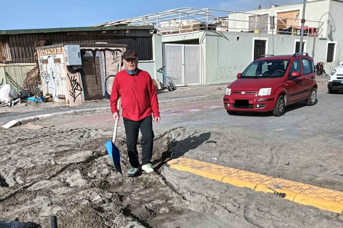 Cittadino al lavoro per pulire la pista ciclabile davanti al Curvone di Ostia