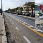 Cittadino spala la sabbia dalla pista ciclabile di Ostia